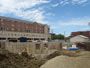 Construction site, July 1, 2014. Short concrete walls built in floor of foundation.