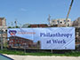 large sign outside construction site saying Philanthropy at work